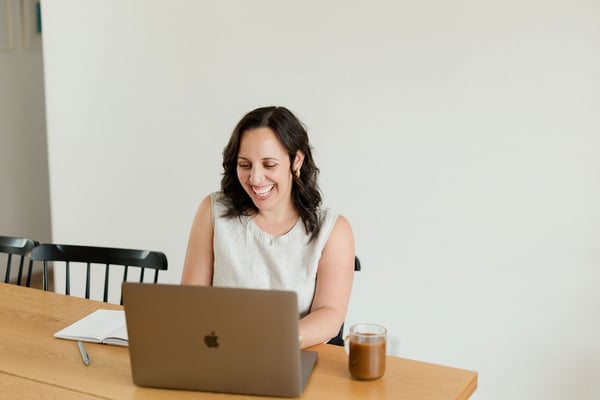 Soof laughing while working on her laptop