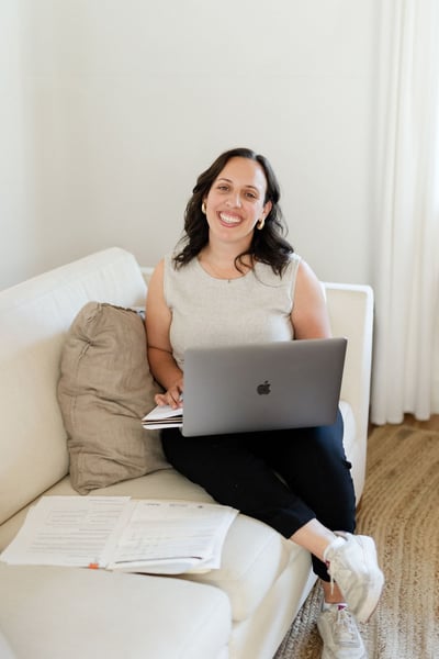 Soof on a sofa with her laptop and paperwork